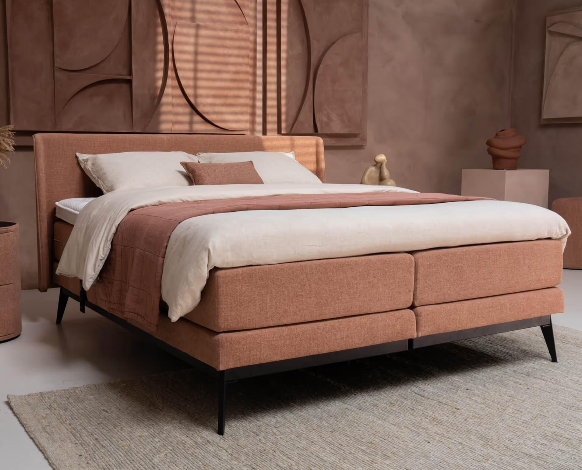 Ubica Torena boxspring in een zachte roze stof met slanke donkere poten