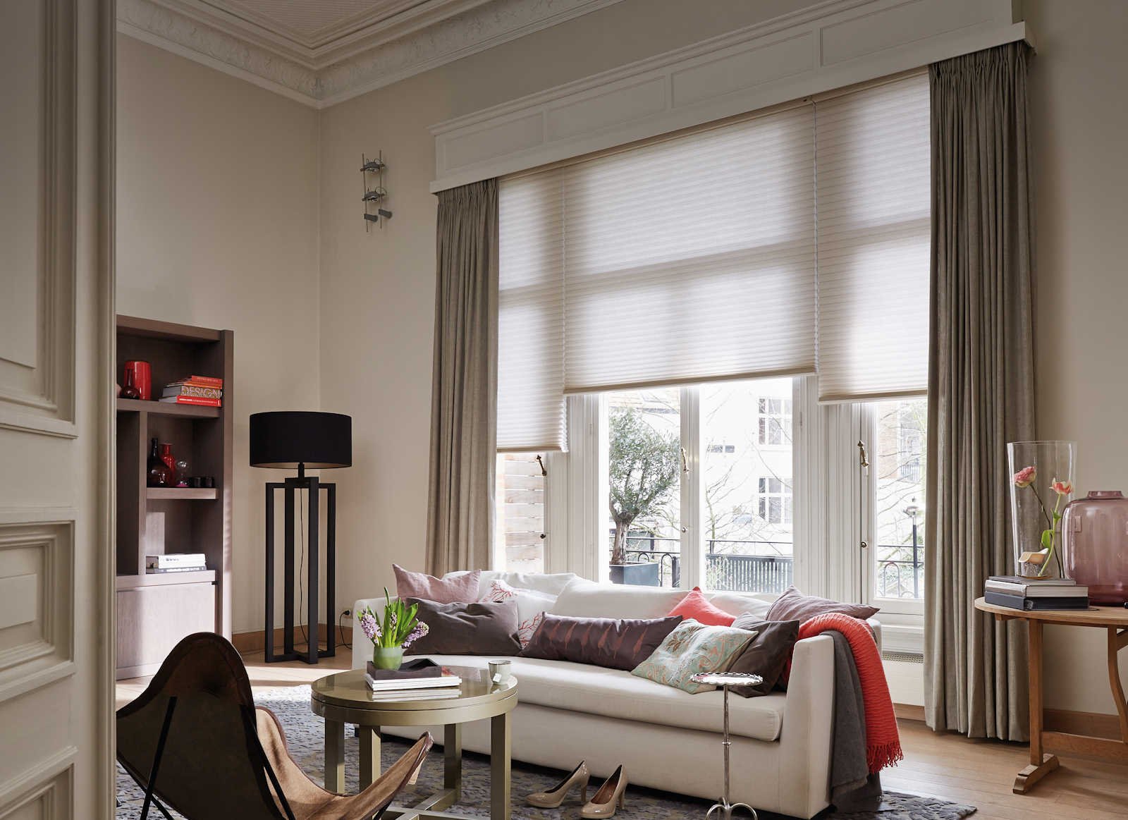 Luxaflex Duette Shades voor hoge ramen, gecombineerd met gordijnen in een woonkamer