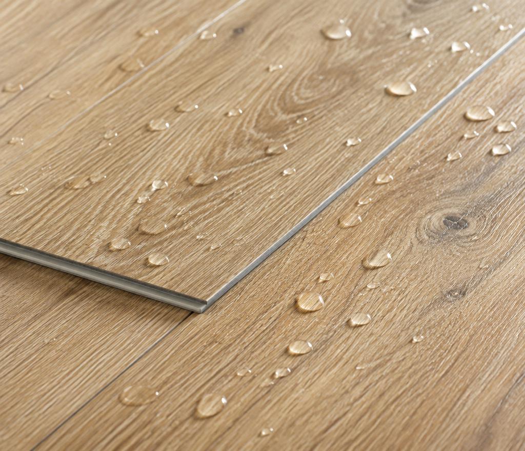 Detail van een waterdichte pvc-vloer met eiken structuur en waterdruppels op het oppervlak